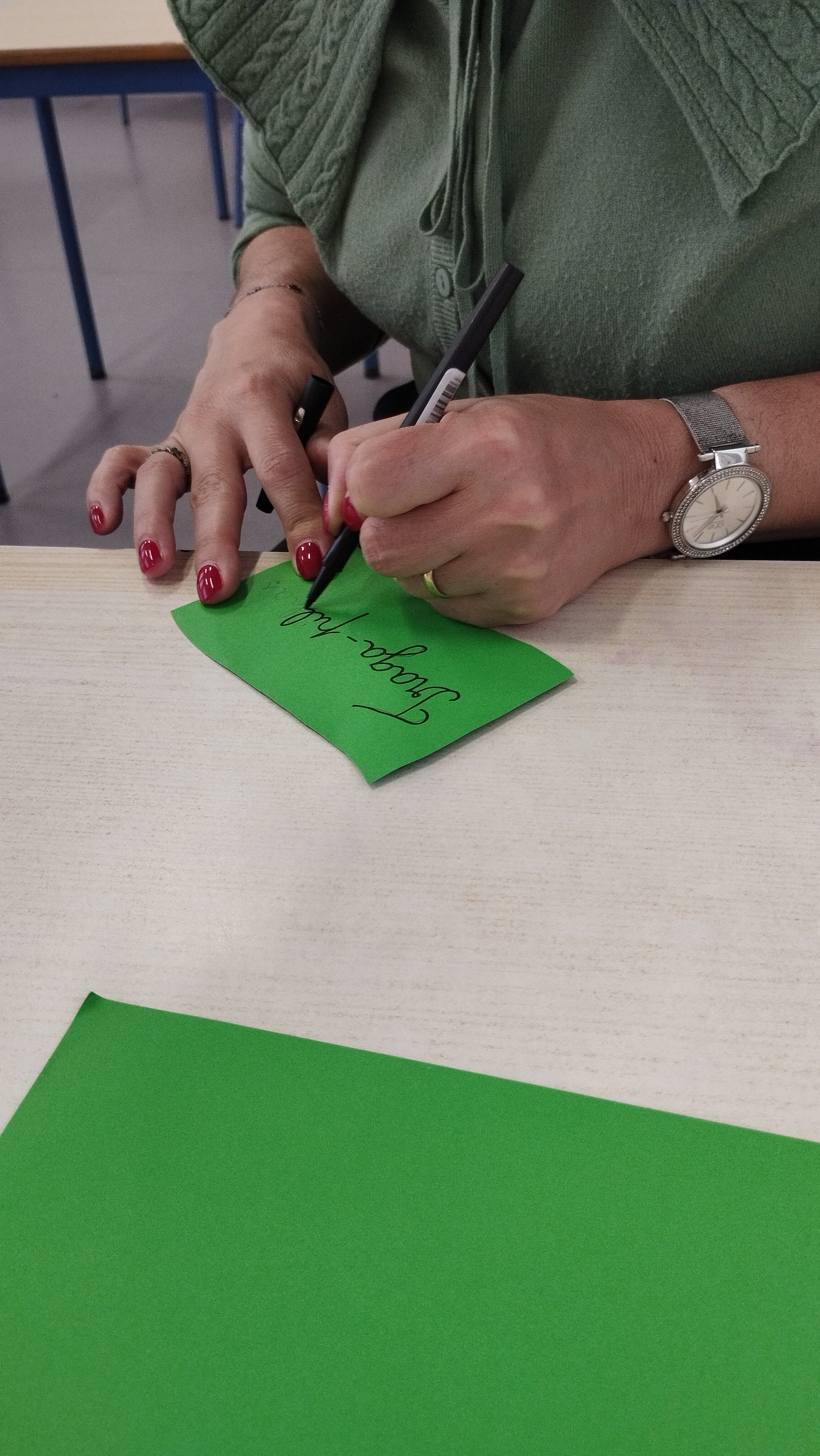 A professora escreve o nome da menina.
